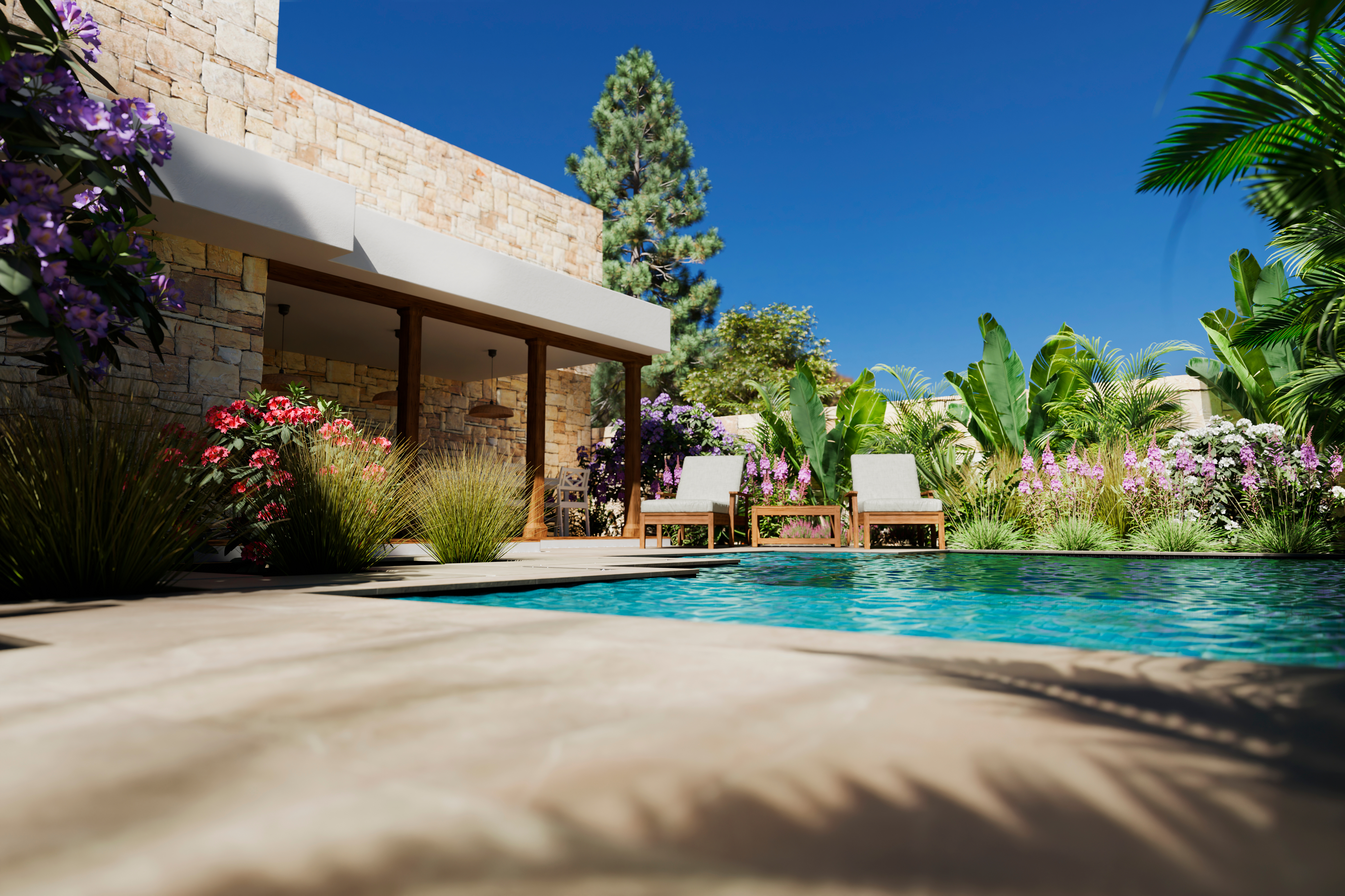 Modern poolside patio with stone house, lounge chairs, and colorful flowering plants under clear blue sky