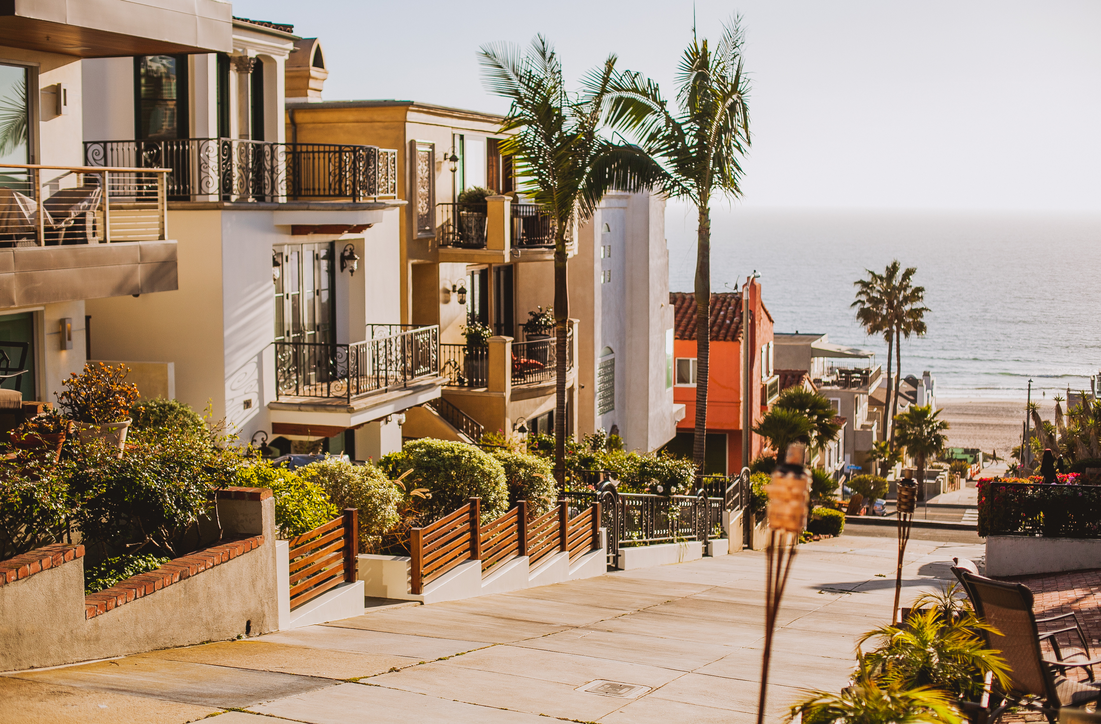Beachfront residential community with modern homes, palm trees, and ocean view in sunny coastal setting